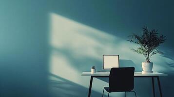 Modern workspace setup with computer, plant, and chair, bathed in soft sunlight against a textured blue wall. Tranquil and minimal design. photo