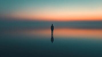 Solitary figure standing on reflective surface under a serene, gradient sky, evoking peace and introspection. Contemplative landscape. photo