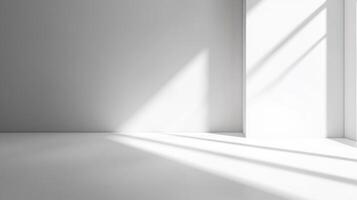Sunlight through a window creates a dramatic display of shadows on a white wall in an empty room. Light and shadow interplay for abstract design. photo