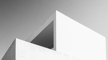 Geometric forms against sky, rendered in monochrome, create a minimalist architectural study, playing with light and shadow. photo