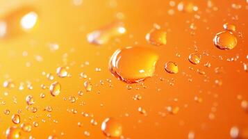 Macro image of water droplets clinging to a vibrant orange surface, reflecting light and showcasing surface tension in delicate detail. photo