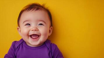 Adorable infant with a joyful expression, wearing a purple onesie, is set against a cheerful yellow backdrop, radiating pure happiness. photo