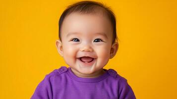 A happy baby, smiling with pure joy, set against a bright yellow backdrop. The infant's face radiates warmth and genuine happiness. photo