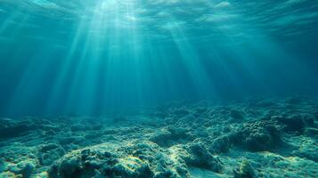 Sunlight filters through clear blue water, illuminating the ocean floor and creating a tranquil underwater scene. Crystal-clear depths. photo