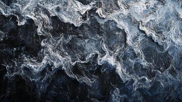 Aerial view of turbulent ocean waters with swirling patterns and dark blue hues creating a powerful and dramatic seascape. photo