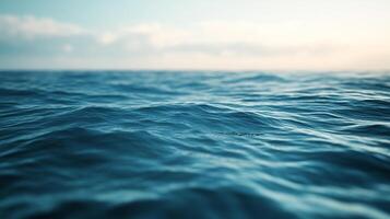 Vast expanse of deep blue ocean water, rippling with small waves, under a soft sky. Gentle motion and a tranquil, natural background. photo