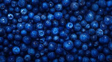 A vibrant array of ripe blueberries create a textured food background. Freshly picked and ready to eat, the berries glisten. photo