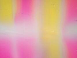 Gradient background blends bright pink and yellow creating a textured surface with a noise effect photo