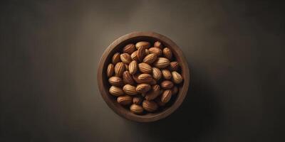 Almonds in a wooden bowl on a dark background photo
