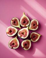 Fresh figs sliced on a pink backdrop with copy space image. photo