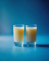 Glasses of fresh apple juice on blue background photo
