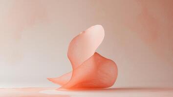 Watercolor brush stroke in soft peach and coral hues creates a delicate and textured abstract shape photo
