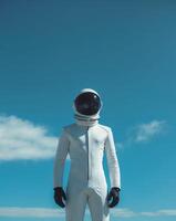 Man in a white spacesuit is standing in front of a blue sky. photo