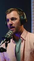 A podcast host speaks into the microphone while sharing insights and engaging in thoughtful discussion during a live recording in a modern studio setting video