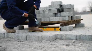Worker installing paving stones with rubber mallet and level video