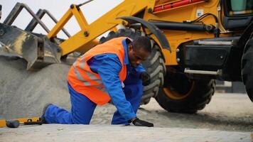 Construction worker installing paving blocks near excavator video