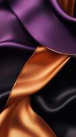 Vibrant silk fabrics in purple, orange, and black flowing gracefully, showcasing their rich textures and colors photo