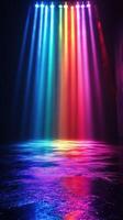 Colorful beams of light illuminate a dark space creating a vibrant atmosphere reflecting on the water surface photo