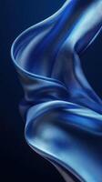 Flowing blue fabric gracefully drapes against a dark background showcasing texture and color photo