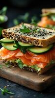 Delicious healthy sandwich with fresh salmon, avocado, and cucumber on whole grain bread photo