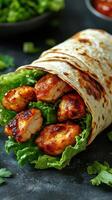 Grilled chicken wrap with fresh lettuce and vibrant herbs served with dipping sauce on a dark background photo