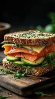 Freshly made sandwich filled with smoked salmon, cheese, and cucumbers on a wooden board in a cozy kitchen setting photo
