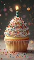 Colorful cupcake with sprinkles and a lit candle celebrates a joyful occasion at a festive gathering photo