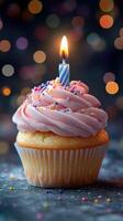 Delicious pink frosted cupcake with a lit candle, celebrating a special occasion at a festive setting photo