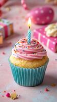 Celebrating with a colorful cupcake and a lit candle in a festive atmosphere filled with gifts and decorations photo