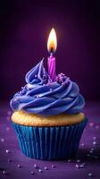 Birthday cupcake with purple frosting and candle glowing softly on a purple background photo
