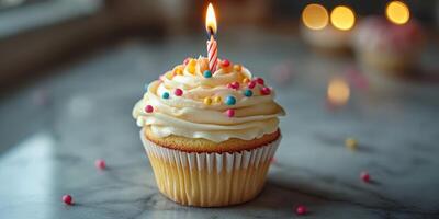Colorful cupcake with a candle on a marble surface for a birthday celebration indoors photo