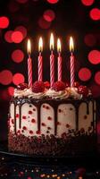 Celebration cake with raspberries and candles illuminated by glowing bokeh lights in the background photo