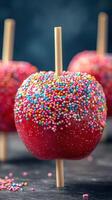 Brightly colored candy apples covered in sprinkles on wooden sticks at a festive celebration photo