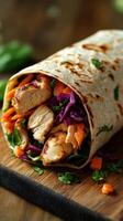 Grilled chicken wrap filled with fresh vegetables and herbs resting on a wooden board in natural light photo