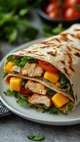 Grilled chicken and mango wrap filled with fresh vegetables on a plate photo