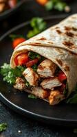 Delicious grilled chicken wrap with fresh vegetables served on a black plate in a cozy dining setting photo