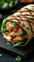 Grilled chicken wrap filled with fresh spinach and herbs on a wooden surface photo