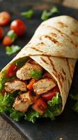 Delicious grilled chicken wrap with fresh vegetables served on a rustic wooden surface photo