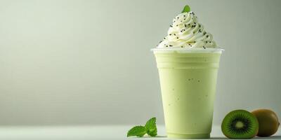 Refreshing green smoothie topped with whipped cream and mint in a clear cup on a light background photo