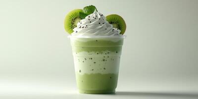 Refreshing green smoothie topped with whipped cream and kiwi slices served in a clear cup photo
