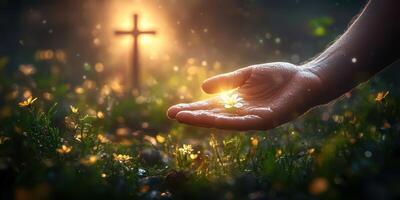 Hand holding a flower in a serene garden at dusk with a glowing cross in the background photo