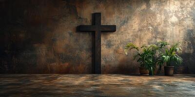 Black wooden cross on textured wall beside green plants in a serene indoor space photo