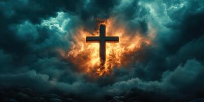 Powerful cross illuminated by fiery clouds in a dramatic sky at twilight photo