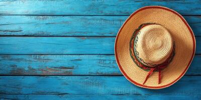 Traditional straw hat resting on a vibrant blue wooden surface in a rustic setting photo