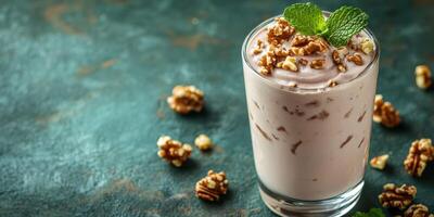 Creamy dessert topped with crunchy nuts and fresh mint leaves on a textured background photo