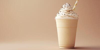 Creamy vanilla milkshake topped with whipped cream and chocolate sprinkles in a clear cup on a beige background photo