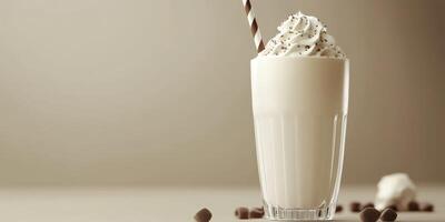 Creamy milkshake topped with whipped cream and chocolate sprinkles served in a tall glass photo