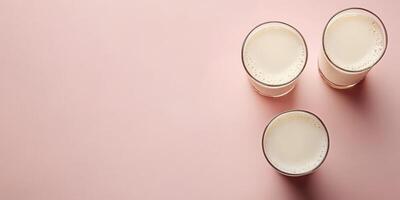 Delicious dairy beverages in three glasses on a soft pink background showcasing a refreshing treat photo