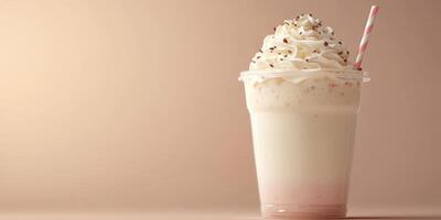 Delicious creamy milkshake topped with whipped cream and chocolate sprinkles in a clear cup with a striped straw photo
