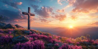 Beautiful sunset over a peaceful mountain landscape with a cross surrounded by blooming flowers photo